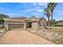 Attractive single-story home boasts a brick driveway, and delightful curb appeal with mature palm trees at 807 Ayden Oak Ln, Ocoee, FL 34761