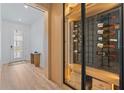 Modern wine cellar featuring glass enclosure, LED lighting, and custom shelving at 8105 Fenton St, Orlando, FL 32836