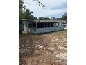 Exterior view of the home showing the back of the home with vinyl siding and an enclosed porch at 1238 Lakecrest Dr, Apopka, FL 32703