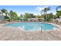 Community pool featuring many lounge chairs, landscaping, and a pergola at 12843 Madison Pointe Cir # 106, Orlando, FL 32821