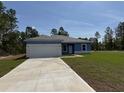New single-story home with blue exterior, gray roof, and a spacious concrete driveway at 15259 Sw 51St Cir, Ocala, FL 34473