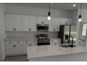 Modern kitchen features stainless steel appliances, white cabinets, and a quartz countertop island at 15259 Sw 51St Cir, Ocala, FL 34473