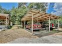 Carport showcasing two parked vehicles, with a partial view of the house and surrounding trees at 18240 Lynbrook Rd, Orlando, FL 32820