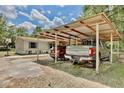 Carport featuring two parked vehicles, with a view of the house at 18240 Lynbrook Rd, Orlando, FL 32820