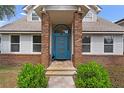 Close-up of the blue front door with brick accents and manicured landscaping at 1901 Lakeshore Cir, Longwood, FL 32750