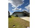 View of the home and long driveway from an angle on the lawn at 2082 Gold Dust Dr, Clermont, FL 34715
