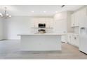 Modern kitchen features white cabinets, stainless steel appliances, and a large center island with sink at 2170 Derwent Dr, Davenport, FL 33896