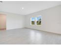 Bright, open-concept living room with modern tile floors and ample natural light from large windows at 2170 Derwent Dr, Davenport, FL 33896
