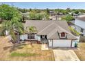 Aerial view of a single-story home showcasing its roofline, landscaping, and proximity to neighborhood trees at 2317 Clearwater Dr, Deltona, FL 32738