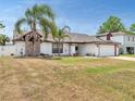 Inviting single-story home featuring a two-car garage and a lawn with mature trees and shrubs at 2317 Clearwater Dr, Deltona, FL 32738