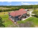 Aerial view of the estate featuring a large brick home, well-manicured lawn, and established landscaping at 240 Spring Forest Dr, New Smyrna Beach, FL 32168