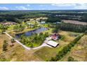 A sprawling estate featuring ponds, a main house, guest house, and horse barn surrounded by lush greenery at 240 Spring Forest Dr, New Smyrna Beach, FL 32168