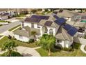 Aerial view of a beautiful two-story home, featuring solar panels on the roof and lush landscaping around the property at 3532 Amaca Cir, Orlando, FL 32837