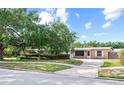Charming brick home with large front yard, mature tree, tidy landscaping, and curved driveway at 4021 Hargill Dr, Orlando, FL 32806