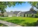 A well-manicured lawn complements this beautiful single-story home with a dark roof and white trim at 4065 Winderlakes Dr, Orlando, FL 32835