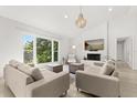 Open concept living room with a large window, neutral furniture, a brick fireplace, and light wood floors at 4065 Winderlakes Dr, Orlando, FL 32835