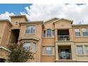 Upward angle of a peach colored, multi-story condo with a balcony at 419 Terrace Ridge Cir # 419, Davenport, FL 33896