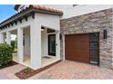 Inviting front entrance featuring a stone accent wall and wood garage door at 4509 Patricia Ann Ct, Orlando, FL 32839