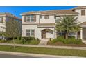 Charming two-story townhouse featuring a well-manicured lawn and a welcoming arched entryway at 4918 Windermere Ave, Kissimmee, FL 34746