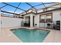 Screened-in pool with clear water, surrounded by a tiled patio area and safety fencing at 4918 Windermere Ave, Kissimmee, FL 34746