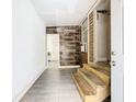 Inviting entrance with unique wood-look accent wall and modern gray flooring, leading to a bright interior at 5050 Howison Rd, Kissimmee, FL 34746