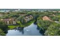 Scenic aerial view of the apartment complex surrounded by lush greenery and a tranquil lake at 5283 Images Cir # 308, Kissimmee, FL 34746