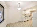 Open concept kitchen with bright white cabinets, stainless steel appliances and tile flooring at 5321 Vineland Rd # 101, Orlando, FL 32811