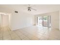 Bright living room with tile floors, ceiling fan, and sliding glass doors to an outdoor patio at 5321 Vineland Rd # 101, Orlando, FL 32811