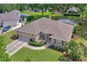 Aerial view showcases a home with manicured lawn, mature trees, and screened pool at 609 Westview Dr, Minneola, FL 34715