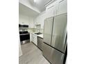 Modern kitchen features stainless steel appliances and sleek white cabinetry at 6328 Raleigh St # 816, Orlando, FL 32835