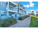 A lovely view of this light-blue building with white trim and beautiful tropical landscaping at 7 Marden Dr, Ormond Beach, FL 32176