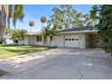 Charming home featuring a two-car garage and a well-maintained lawn with palm trees at 7046 Treasure Island Rd, Leesburg, FL 34788