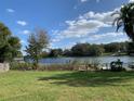 Expansive backyard overlooking a serene lake with mature trees and a private dock at 7508 Lake Marsha Dr, Orlando, FL 32819