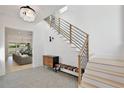 Bright foyer with modern chandelier, staircase with wood and iron railing, and stylish bench at 833 Dartmouth St, Orlando, FL 32804