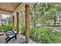 Inviting front porch features wooden pillars and a view of the lush, green neighborhood at 833 Dartmouth St, Orlando, FL 32804