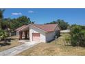 Cozy single-story home featuring a pink-toned garage door and a well-maintained, fenced yard at 857 E Flag Ln, Kissimmee, FL 34759