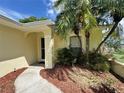 Inviting entrance with a well-manicured garden and a paved walkway to the front door at 8829 Courtyard Ln, Groveland, FL 34736