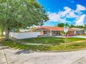 Charming home with a manicured lawn, stone accents and a red exterior, surrounded by lush greenery at 898 Hendry Dr, Orlando, FL 32822