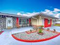 Stylish home showcasing unique stone accents, vibrant red details, and a neatly landscaped front yard at 898 Hendry Dr, Orlando, FL 32822