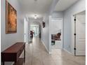 Bright hallway featuring neutral walls, tile flooring, and access to various rooms in the home at 6768 Coral Berry Dr, Mount Dora, FL 32757