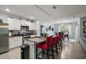 Modern kitchen with white cabinets, granite countertops, stainless steel appliances, and a breakfast bar at 6768 Coral Berry Dr, Mount Dora, FL 32757