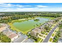 Beautiful aerial view of lakeside homes showcasing mature trees, a neighborhood lake, and lush landscaping at 1000 Park Club Dr, Kissimmee, FL 34746