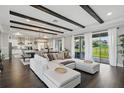 Bright open-plan living room featuring hardwood floors, beamed ceiling, and floor-to-ceiling sliding glass doors at 10196 Bucklow Hill Dr, Orlando, FL 32832