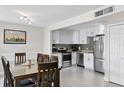Bright dining and kitchen area features white cabinets, stainless appliances, and gray tile backsplash at 1020 Grove St # 29, Maitland, FL 32751