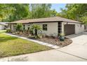Attractive single-story house with a manicured lawn, landscaped garden and a convenient two-car garage at 1113 Black Acre Trl, Winter Springs, FL 32708