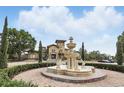 Beautiful clubhouse featuring an ornate fountain, manicured landscaping, and ample parking spaces at 114 Vista Verdi Cir # 136, Lake Mary, FL 32746