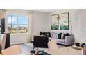 Bright living room featuring a comfortable sofa, stylish decor, and a large window at 1196 Alstonia Ln, Mount Dora, FL 32757
