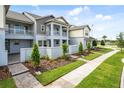 Charming townhome with a landscaped front yard and a view of the community park at 14259 Kellogg Ave, Orlando, FL 32827