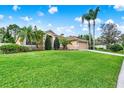 Charming single-story tan home boasts a lush green lawn and well-maintained landscaping at 1585 Maidencane Loop, Oviedo, FL 32765