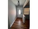 Inviting entryway featuring wood flooring and a decorative light fixture above the white front door at 1603 Gaston Foster Rd, Orlando, FL 32812